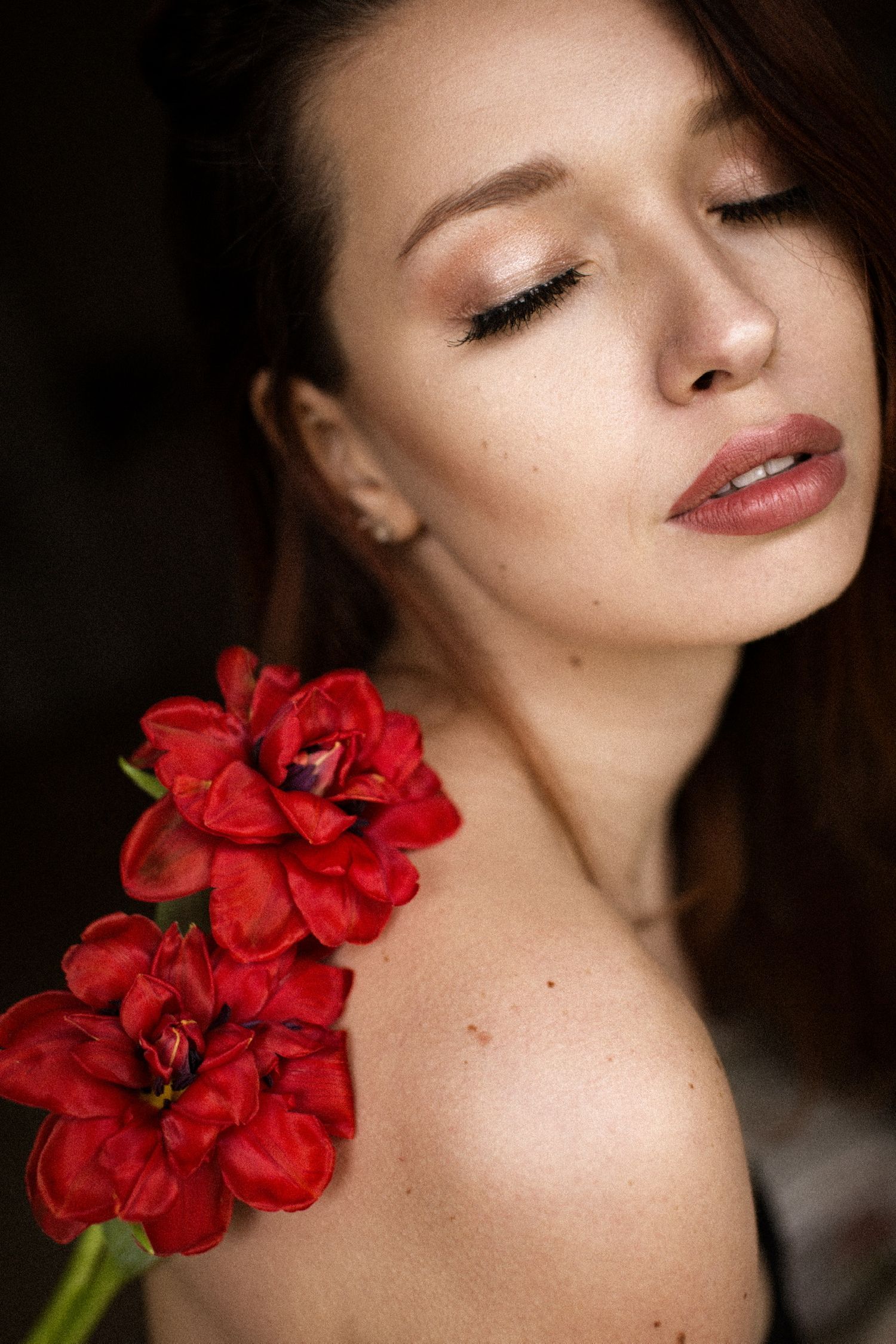 Frau schaut verträumt mit Blumen auf der Schulter – sinnliches Portraitfoto Julia Kippes