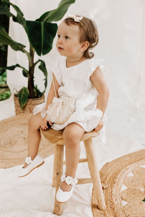 Kleines Mädchen in weißem Kleid sitzt auf einem Holzhocker – Kinderfotografie Julia Kippes in Bielefeld