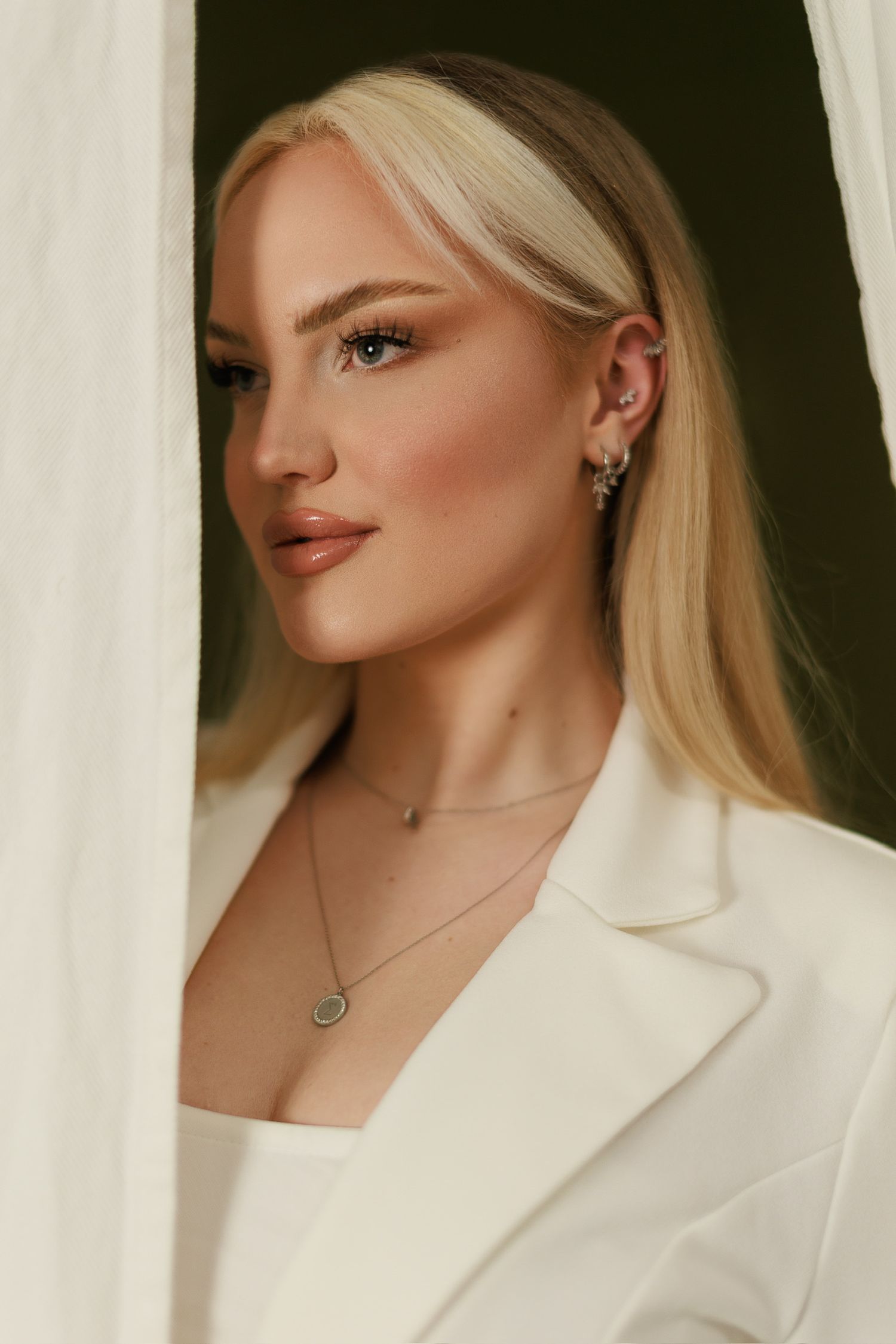 Blonde Frau vor grünem Hintergrund – natürliches Portraitfoto Julia Kippes in Bielefeld